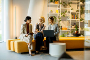 Three female employees with good professional attitude are talking to each other.